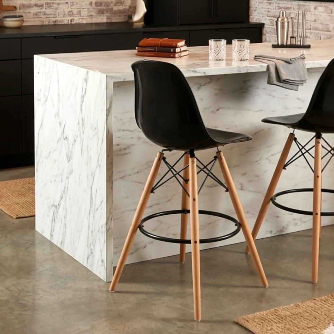 Modern acrylic bar chair with break-resistant seat, metal chassis, beech wood legs, and metal footrest in Scandinavian style.