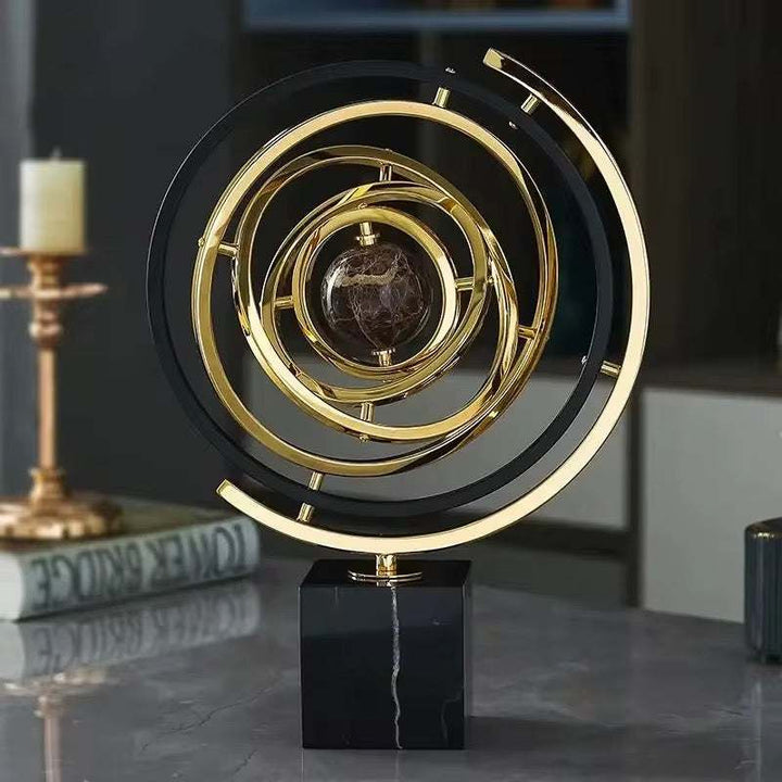 Luxury orbital ring sculpture with gold and black concentric circles and marble center
