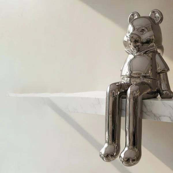 Chrome bear sitting sculpture with reflective finish on display unit