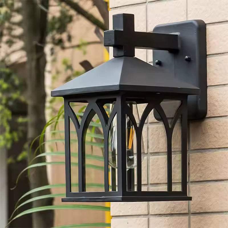Outdoor wall lantern light with weather-resistant metal frame and clear glass panels mounted on exterior wall