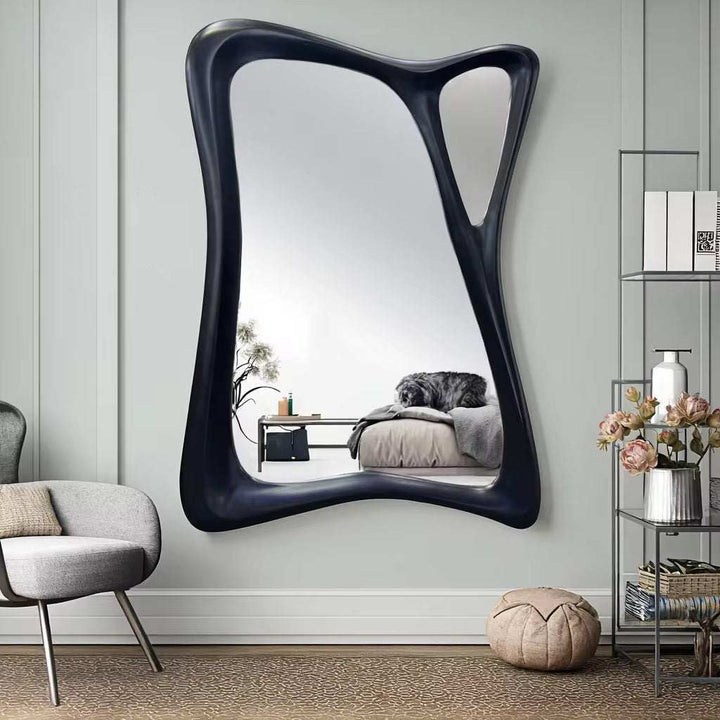 Abstract sculptural wall mirror with unique asymmetrical frame and bold modern design for living rooms or hallways