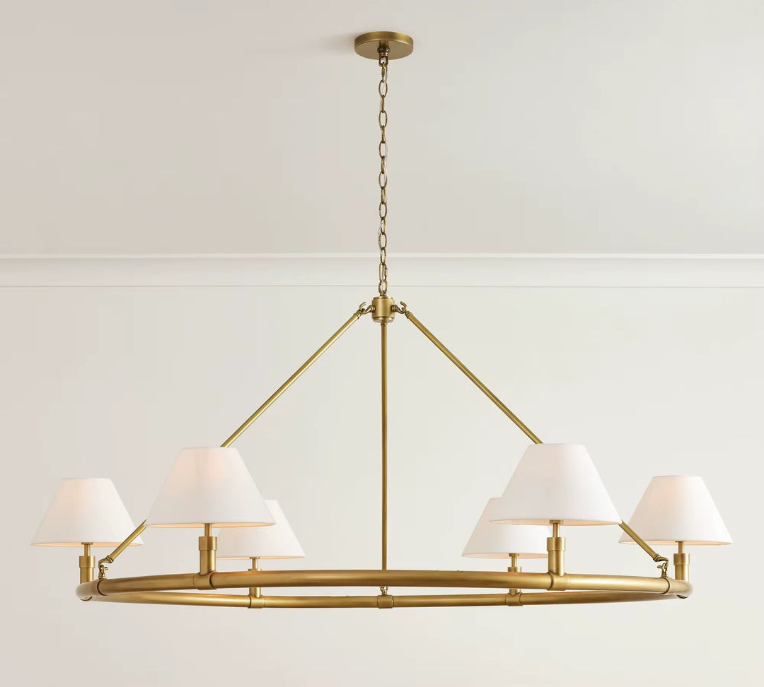 Modern brass linear chandelier with six white fabric shades suspended from a ceiling chain