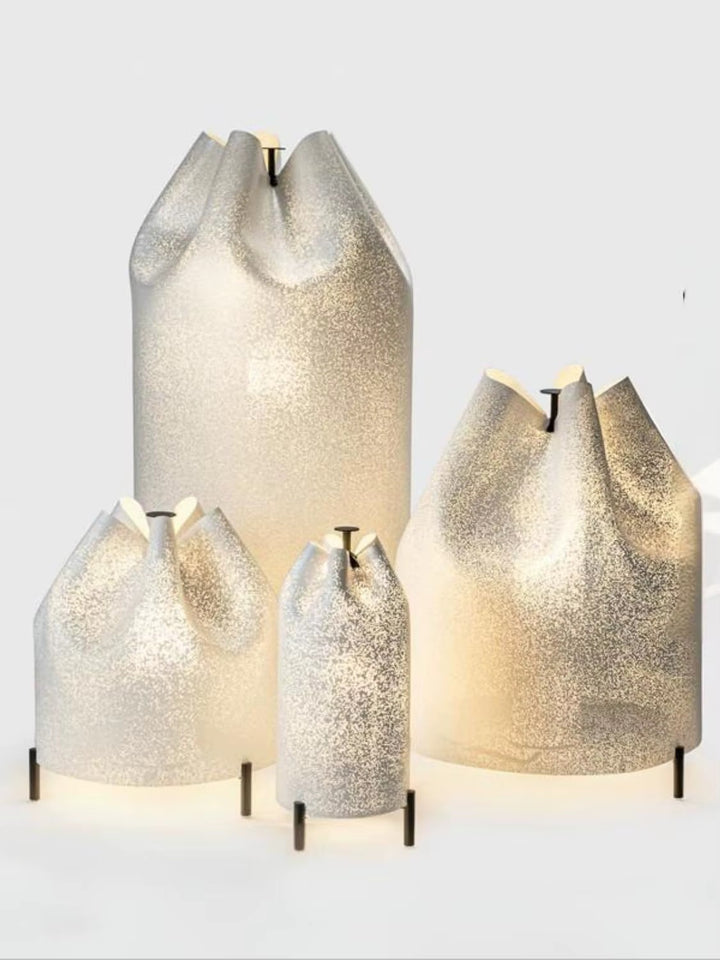 Sculptural translucent textured table lamp with a warm white glow and slim black metal legs