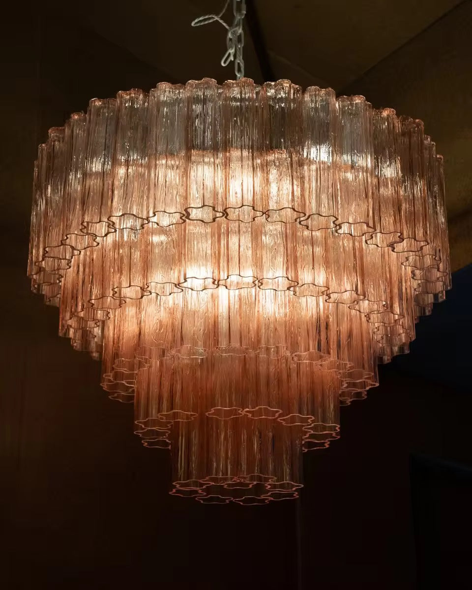 Cascading amber glass tiered chandelier with ribbed glass elements and glowing warm illumination