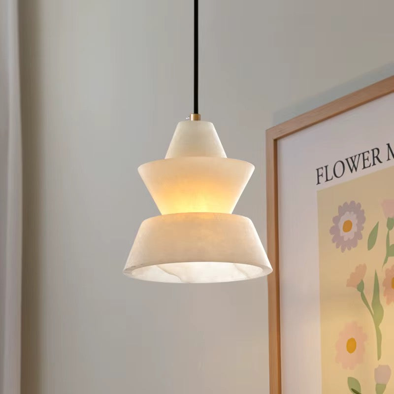 Sculptural white layered pendant light hanging from a black cord