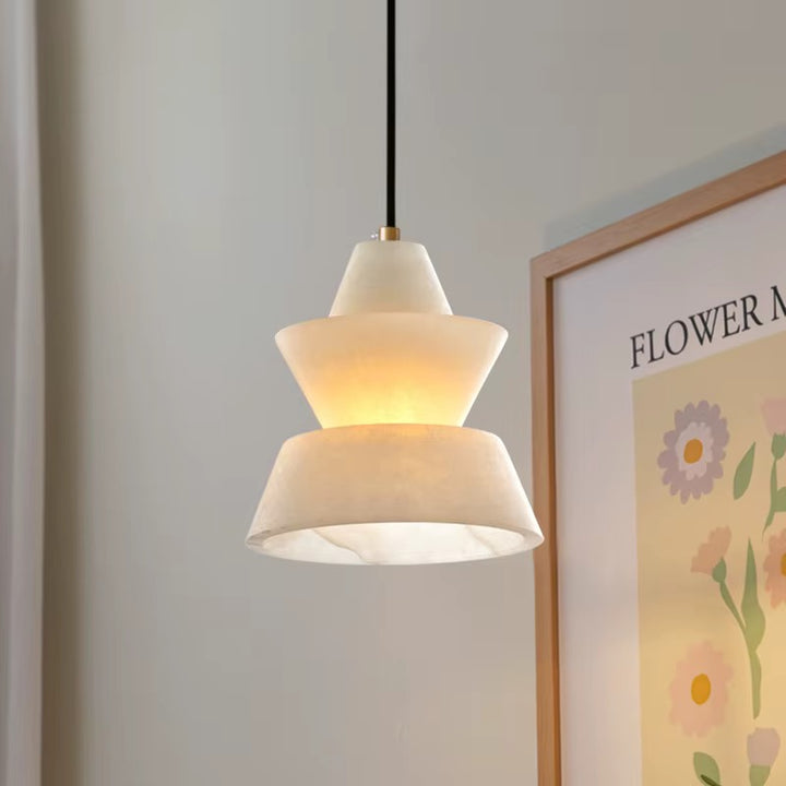 Sculptural white layered pendant light hanging from a black cord