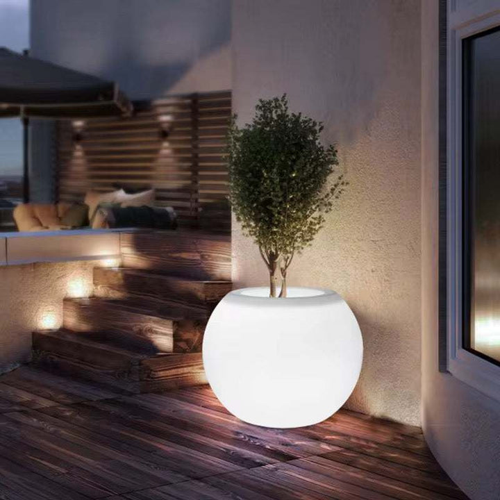 Illuminated outdoor planter light with integrated greenery and ambient terrace lighting