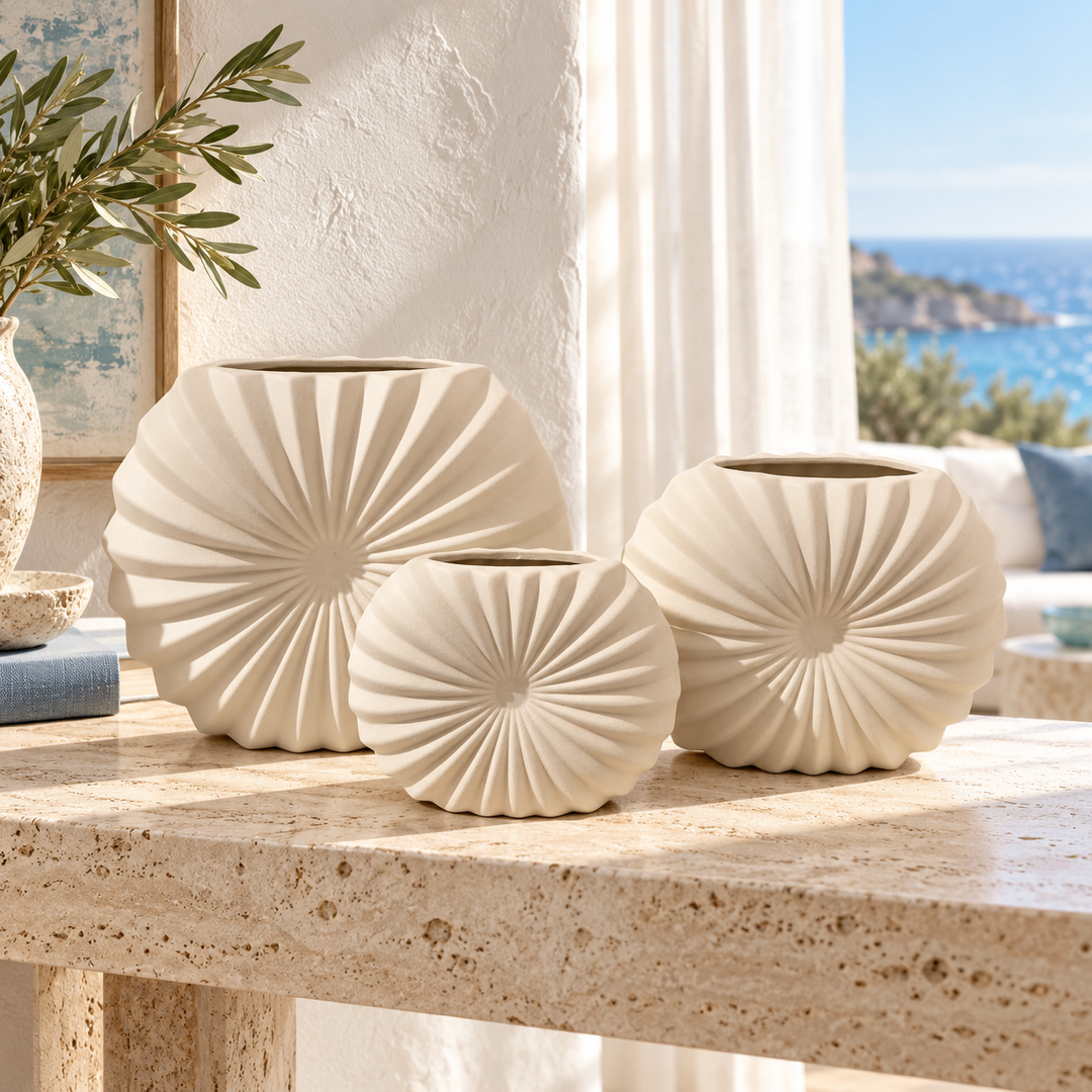 Set of three cream ribbed ceramic fan-shaped vases displayed on a stone console table