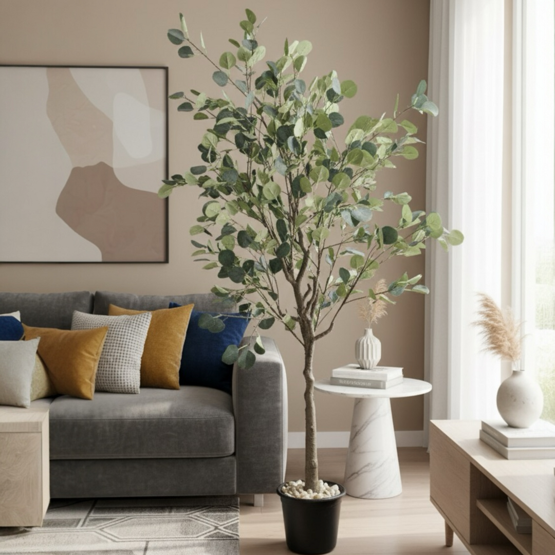 Artificial ficus tree with round green leaves in a black pot placed beside a sofa in a modern living room