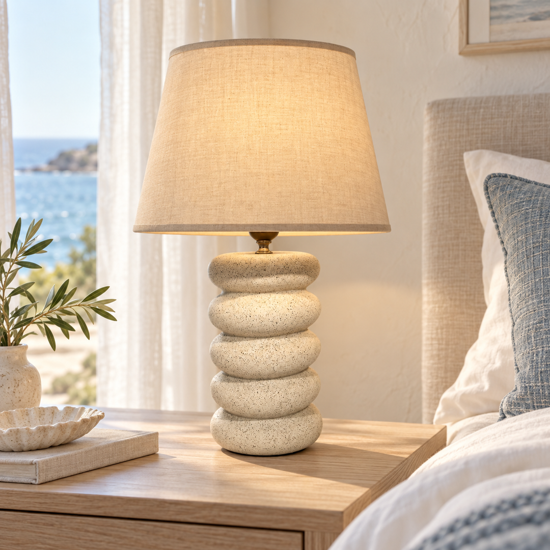 Cream table lamp with a speckled stacked-form base and beige tapered shade