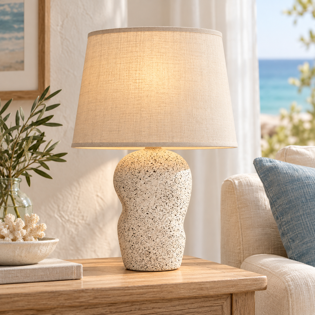 Beige table lamp with an organic-shaped speckled base and tapered fabric-look shade