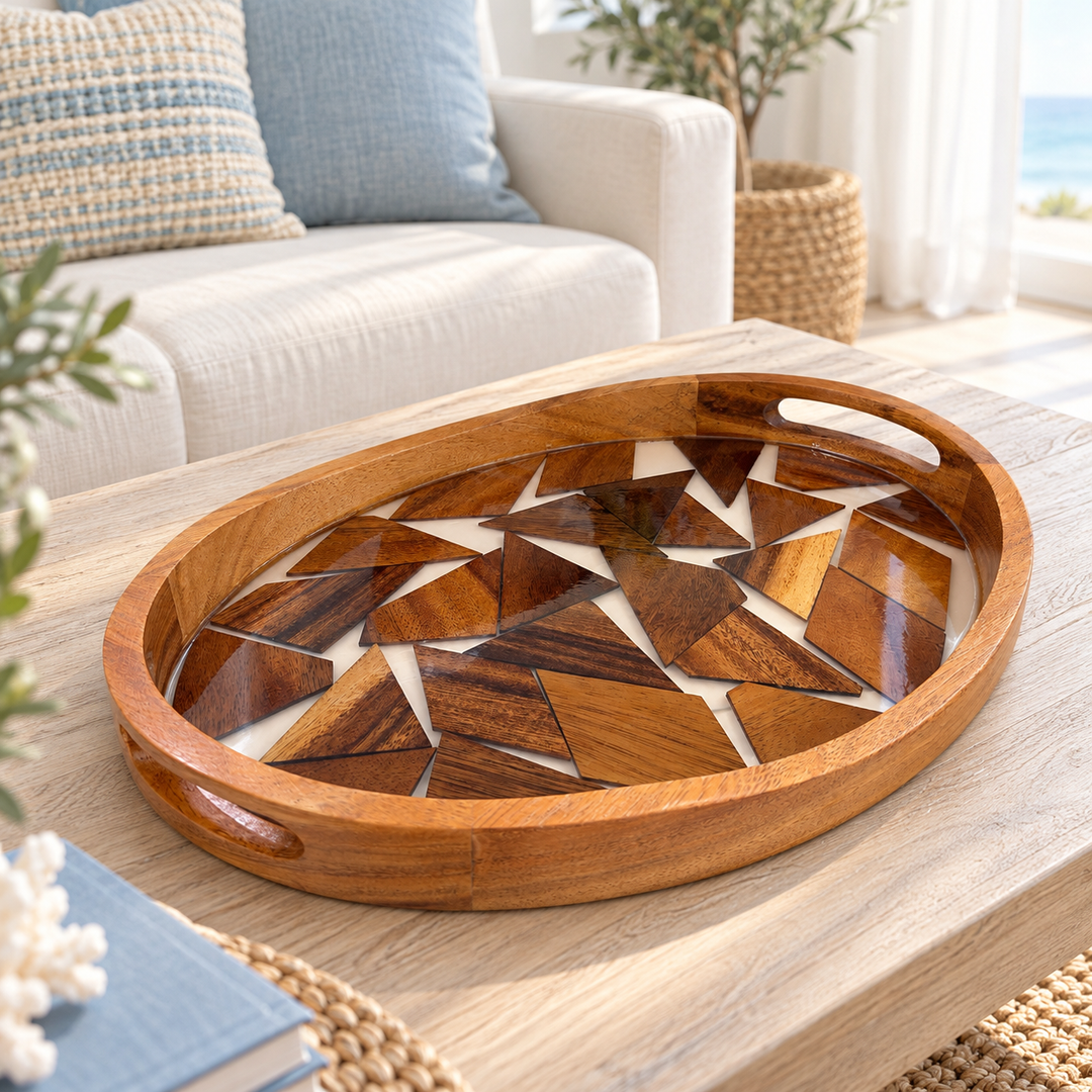 Oval wooden tray with a raised rim, cutout handles, and geometric mosaic inlay, placed on a light coffee table.