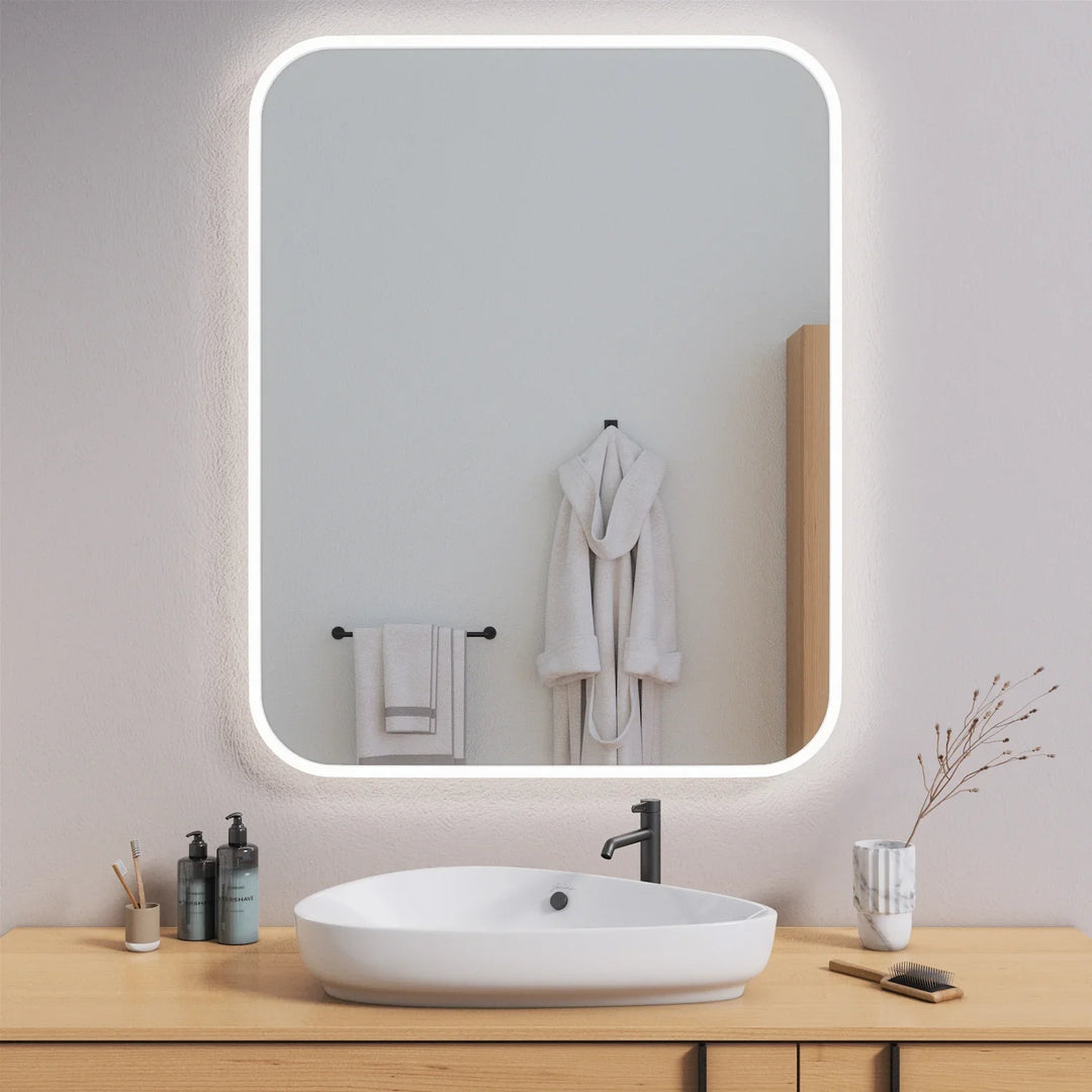 Rectangular LED vanity mirror with rounded corners and soft edge lighting above modern sink
