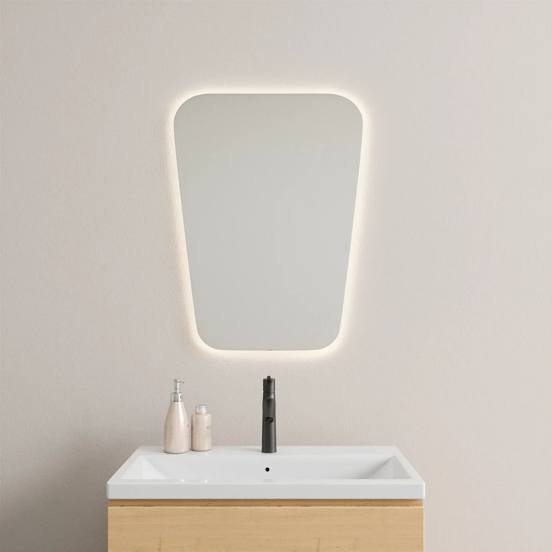 Tapered retro LED mirror with soft backlight above white vanity