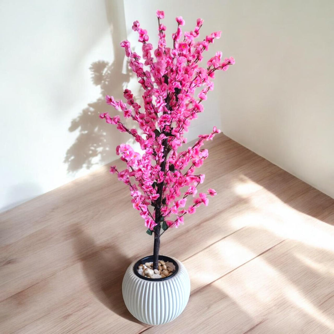Artificial cherry blossom tree with pink flowers in a white ribbed pot