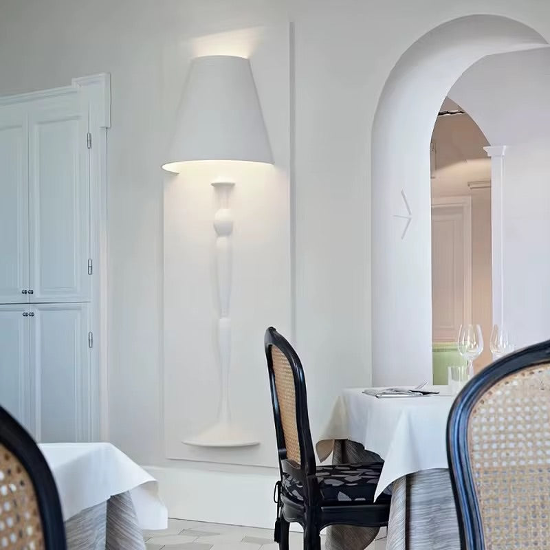 Dining room with white walls, a tall lamp, and a table set for dinner.