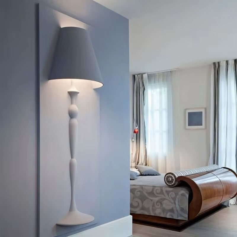 Modern bedroom with a unique bed design and a tall floor lamp.