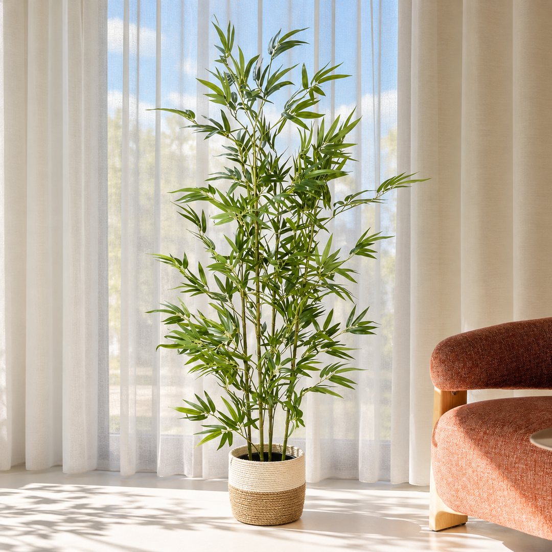 160 cm artificial bamboo tree with slender green canes and narrow leaves in a cream and natural woven basket pot beside sheer curtains.