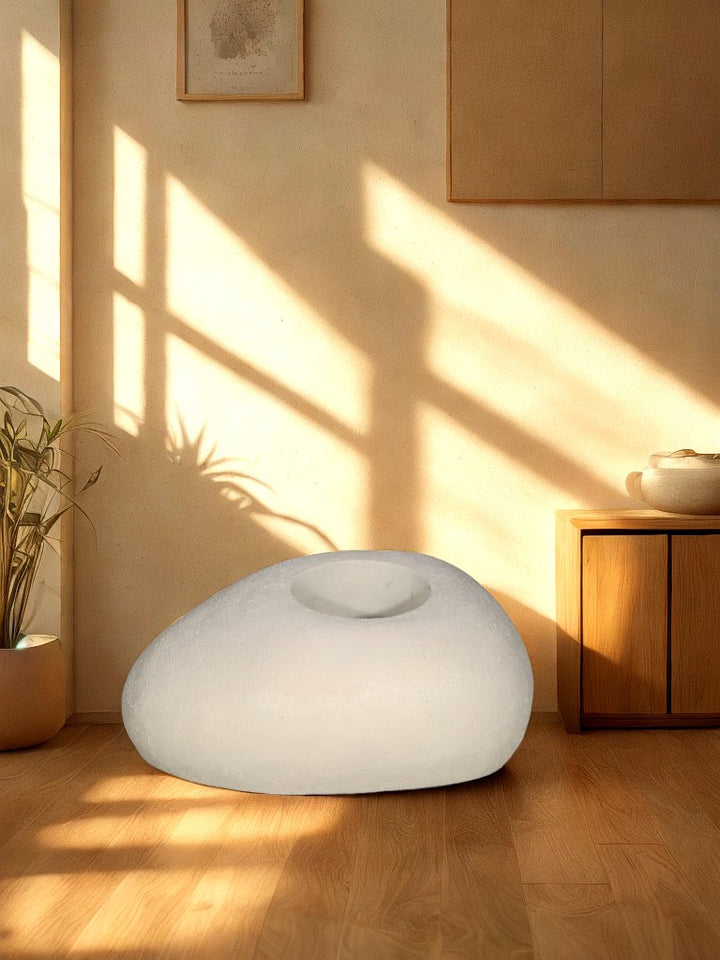 Cream pebble-shaped textured fiberglass planter with a recessed round opening styled in a warm living room.