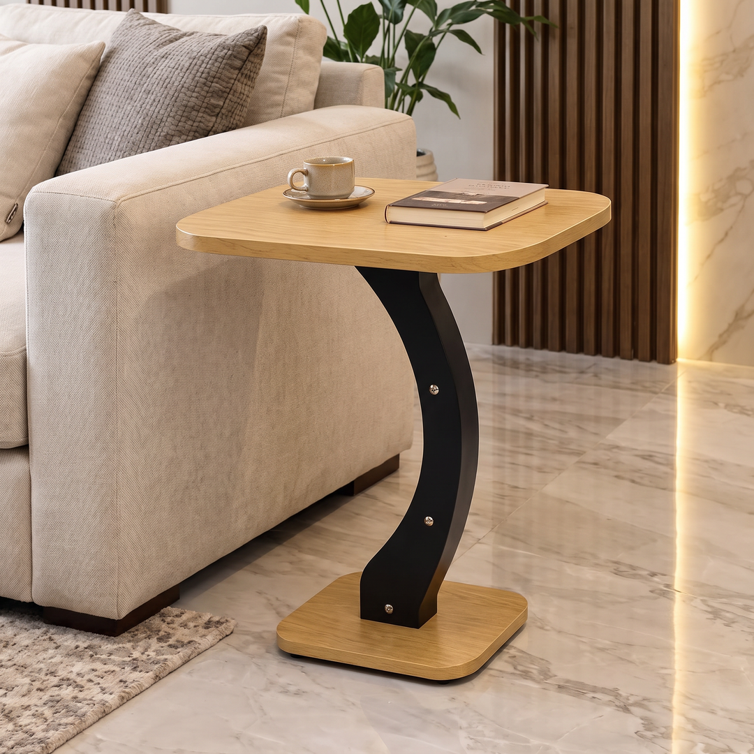Curved side table beside a cream sofa with a coffee cup and book