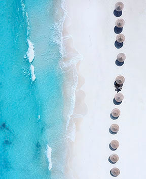 Aerial view of beach umbrellas on turquoise ocean shore canvas wall art