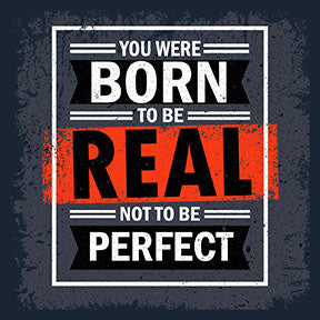 Wadi Home motivational wall art with bold white text on dark grey background: "You Were Born To Be Real Not To Be Perfect".