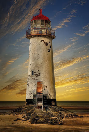 Wadi Home Coastal Lighthouse Sunset Wall Art featuring a white lighthouse with a red roof against a vibrant orange and blue sunset sky.