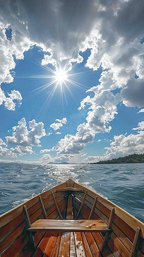 Wadi Home wooden boat art print, view from inside the boat looking out at a bright blue sky with clouds and sun over the water.