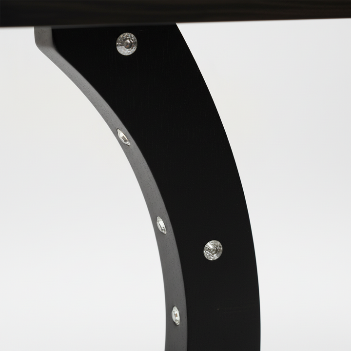 Close-up macro detail of curved table frame with professional lighting