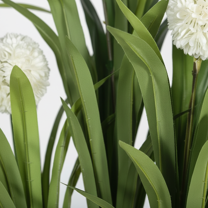 Close-up of artificial monstera split leaves on white studio background