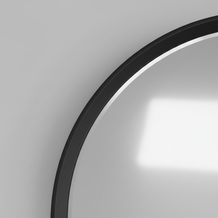 Close-up of the black frame edge meeting the mirror glass