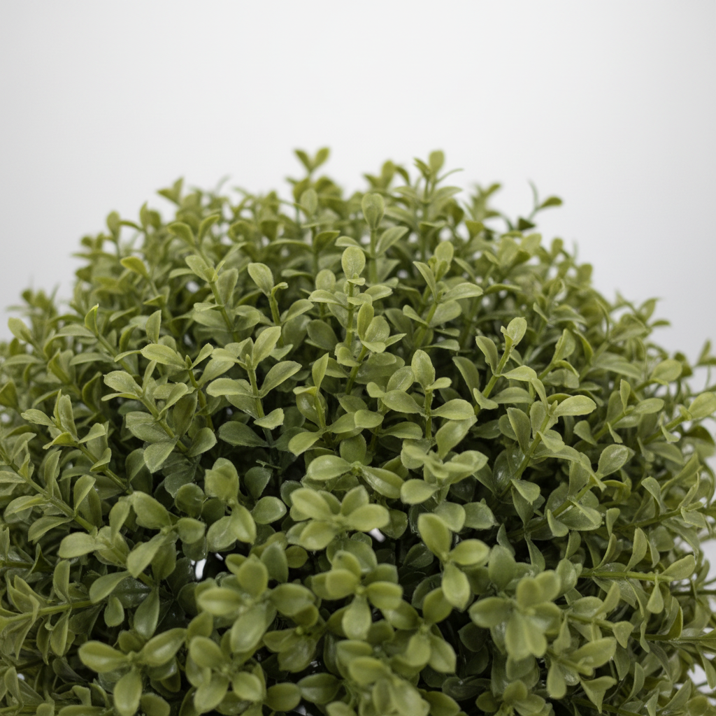 Close-up of artificial fern delicate feathery fronds on white studio background