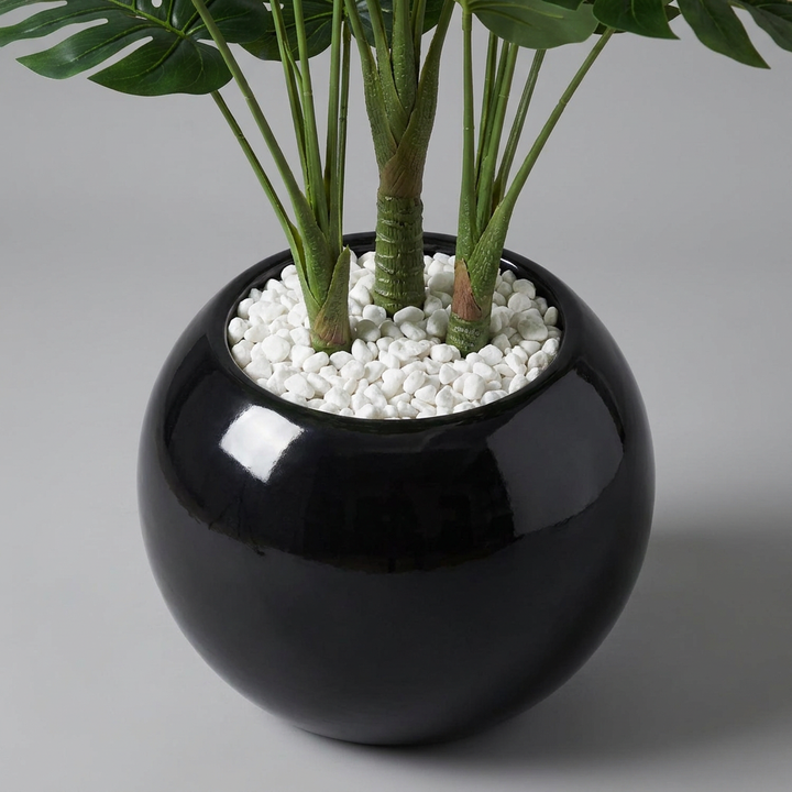 Close-up of artificial plant pot and trunk base on gray background