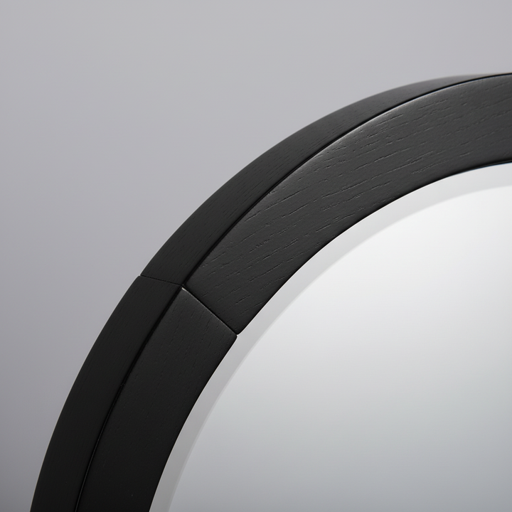 Close-up macro of black wooden frame corner showing wood grain and finish quality