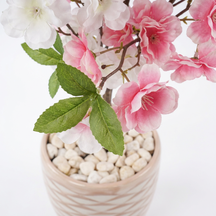 Close-up macro shot of artificial plant leaves with white pebbles