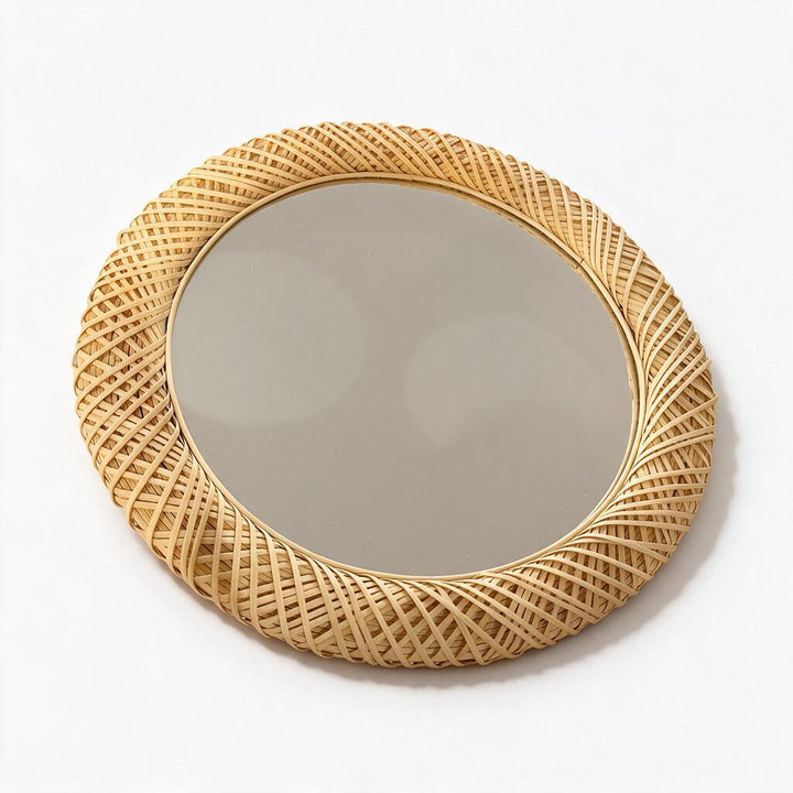 Round woven rattan wall mirror on white studio background
