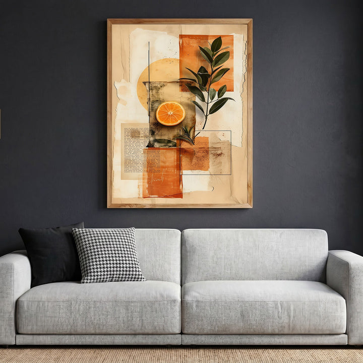 Wadi Home abstract botanical collage wall art with citrus and foliage in a wooden frame above a modern grey sofa.