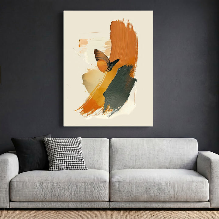 Wadi Home abstract butterfly wall art with burnt orange and charcoal brushstrokes hanging above a modern grey sofa.