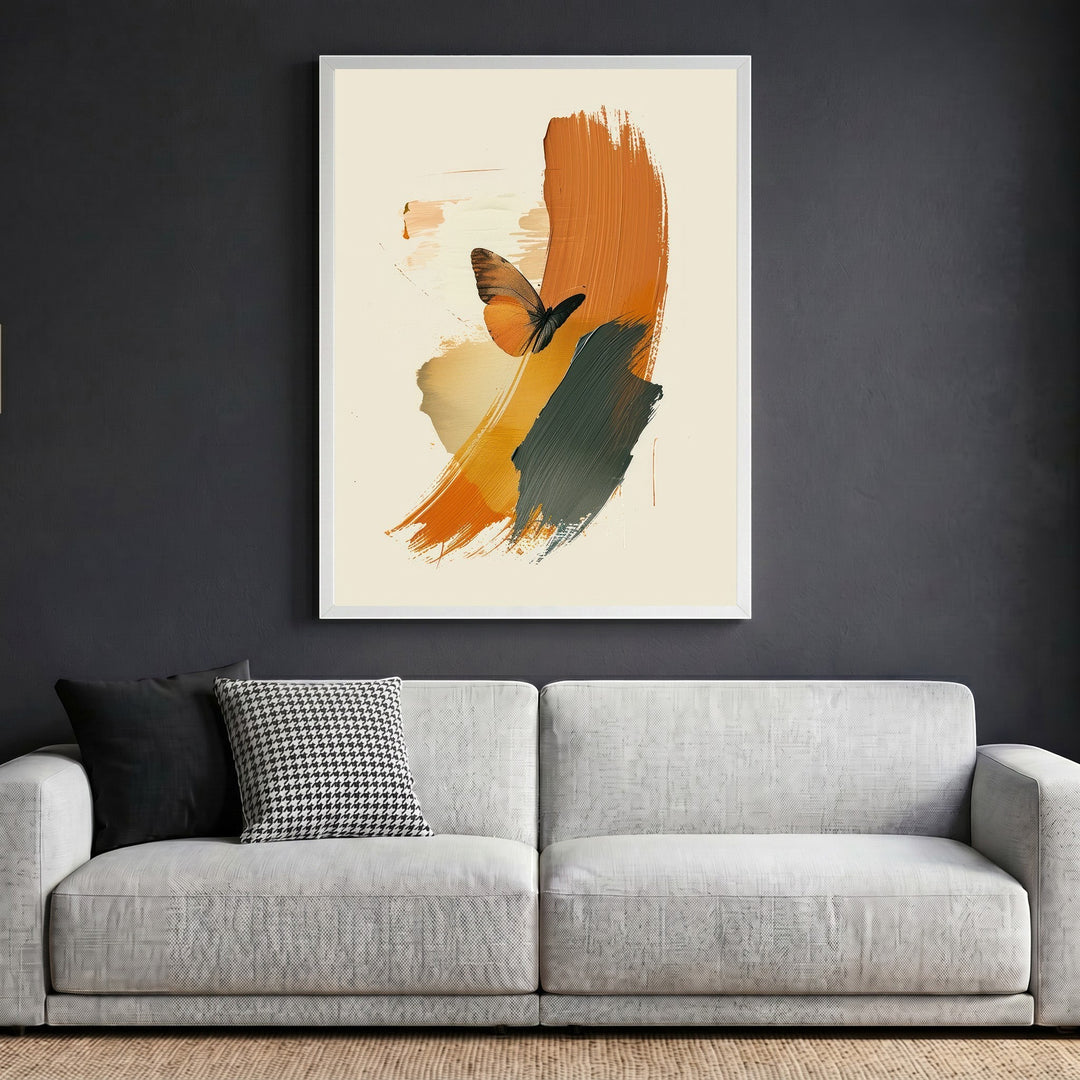 Wadi Home abstract butterfly wall art print with burnt orange and charcoal brushstrokes in a white frame above a sofa.