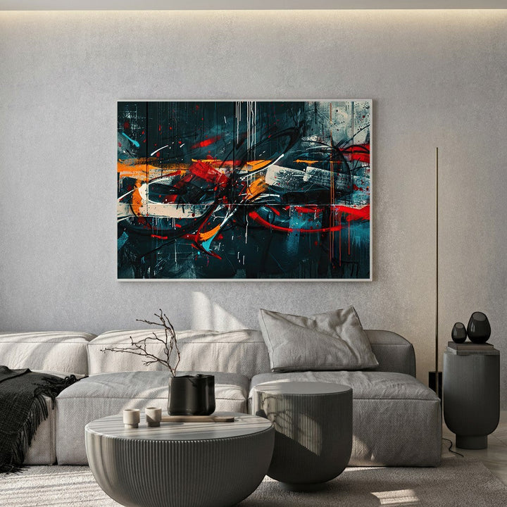 Wadi Home abstract expressionist framed wall art with moody tones and vibrant red and orange accents above a grey sofa.