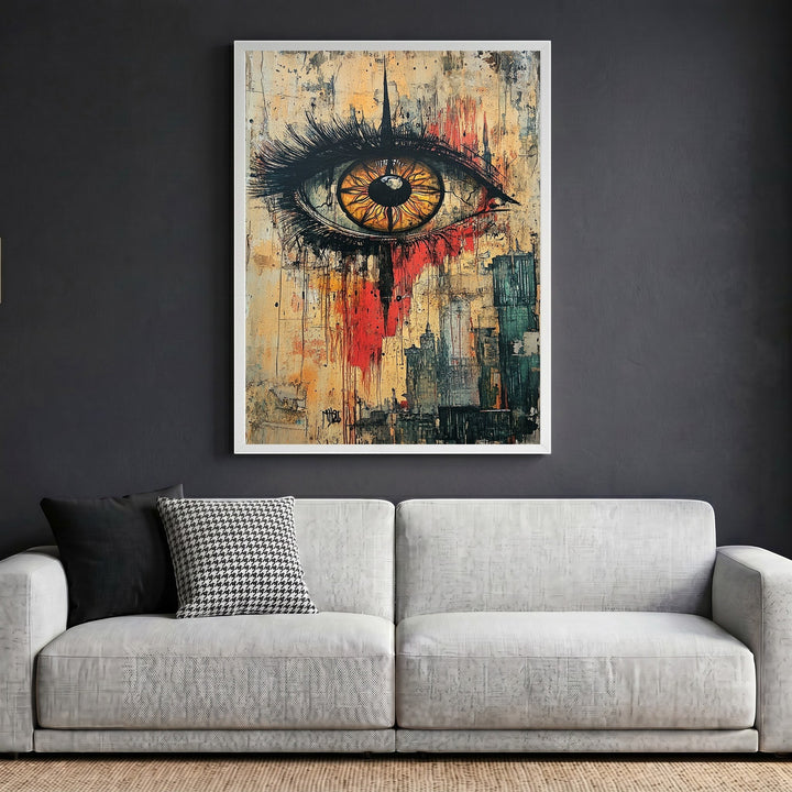 Wadi Home abstract eye wall art in a white frame hanging above a modern grey sofa in a living room.