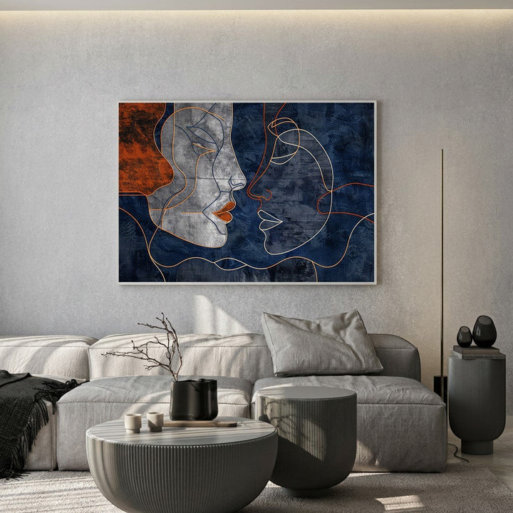 Wadi Home abstract faces line art canvas print with navy and terracotta tones displayed above a modern grey sofa.
