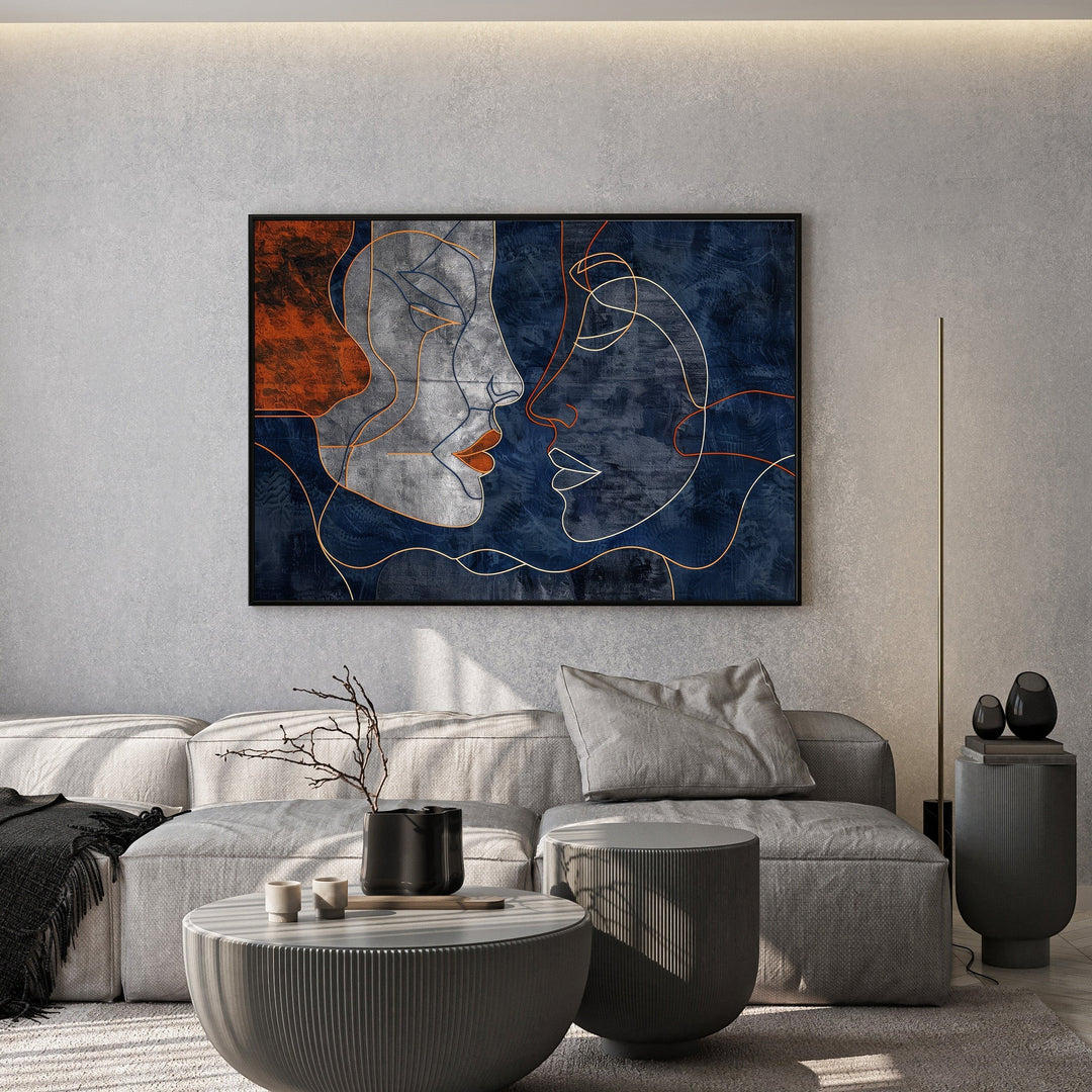 Wadi Home abstract faces line art canvas print with navy and terracotta tones hanging above a modern grey sofa.