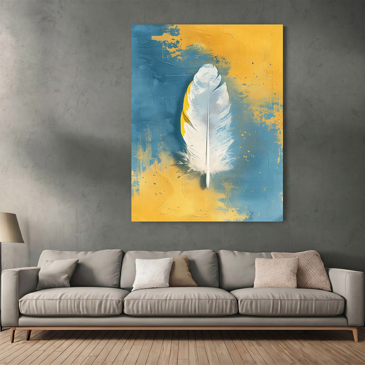 Wadi Home abstract feather canvas print with white feather on textured blue and yellow background above a grey sofa.