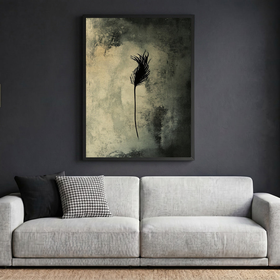 Wadi Home abstract feather wall art print in a black frame hanging above a modern white sofa in a living room.