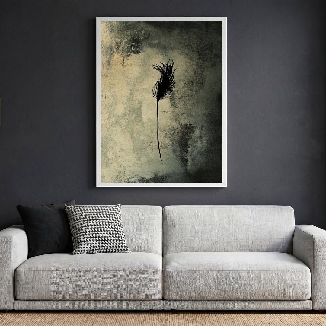 Wadi Home abstract feather wall art print in a white frame hanging above a modern grey sofa in a living room.