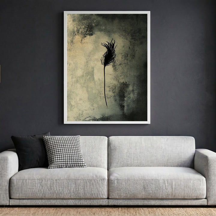 Wadi Home abstract feather wall art print in a white frame hanging above a modern grey sofa in a living room.
