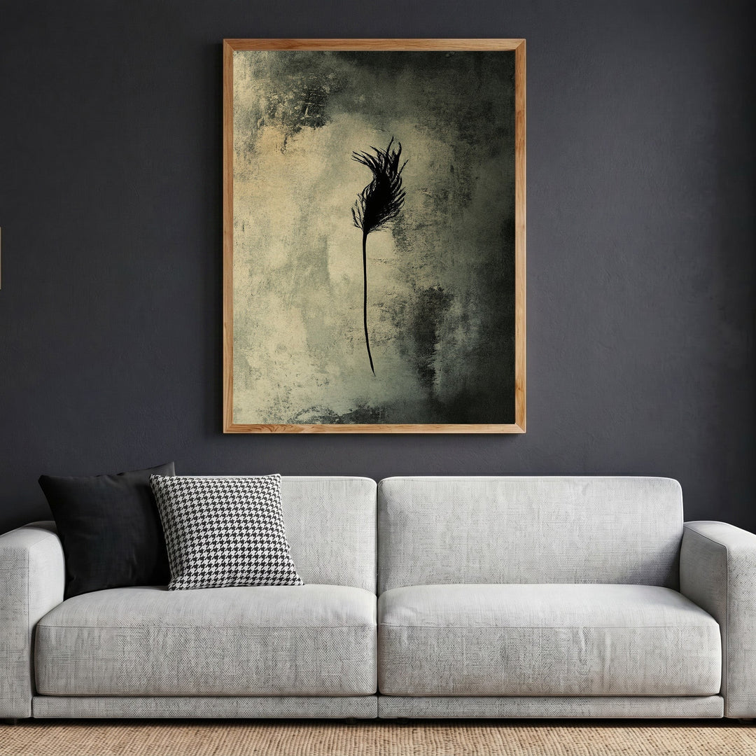 Wadi Home abstract feather wall art print in a wooden frame hanging above a modern grey sofa in a living room.