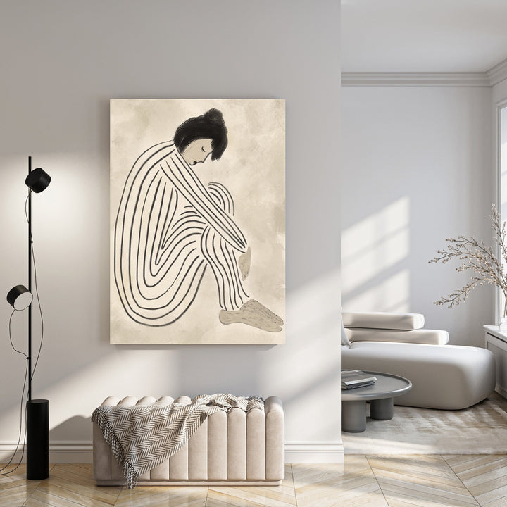 Wadi Home abstract wall art of a figure in black and white stripes, seated and hugging knees, on a textured neutral background.