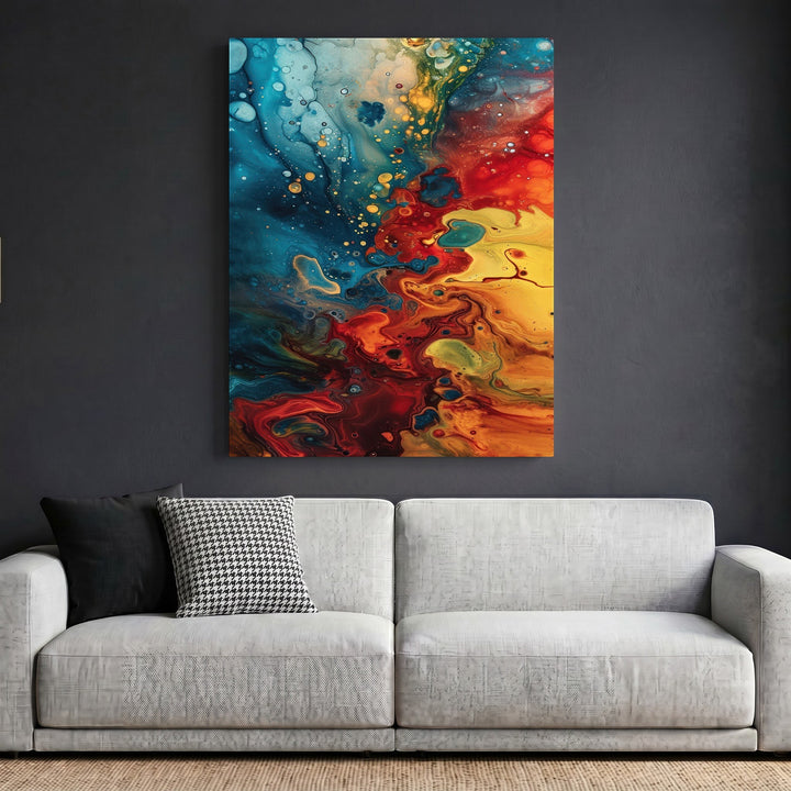 Wadi Home abstract fluid art canvas print with blue, red, and yellow swirls hanging above a modern grey sofa.